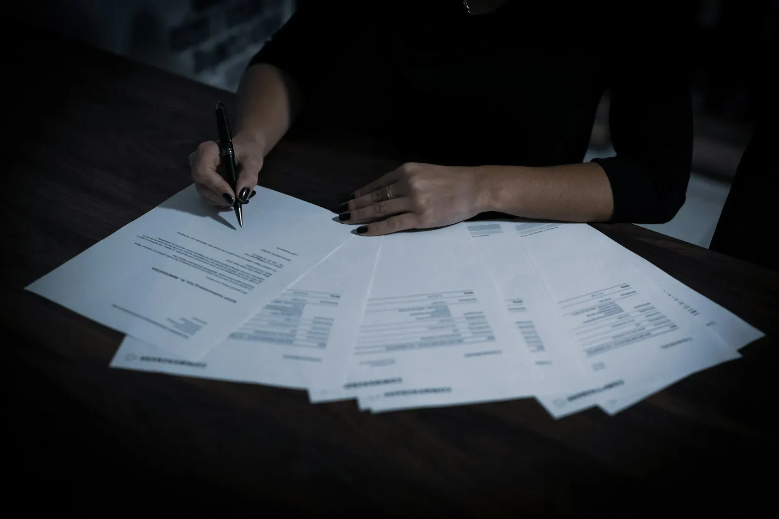 Manos revisando varios documentos sobre la mesa